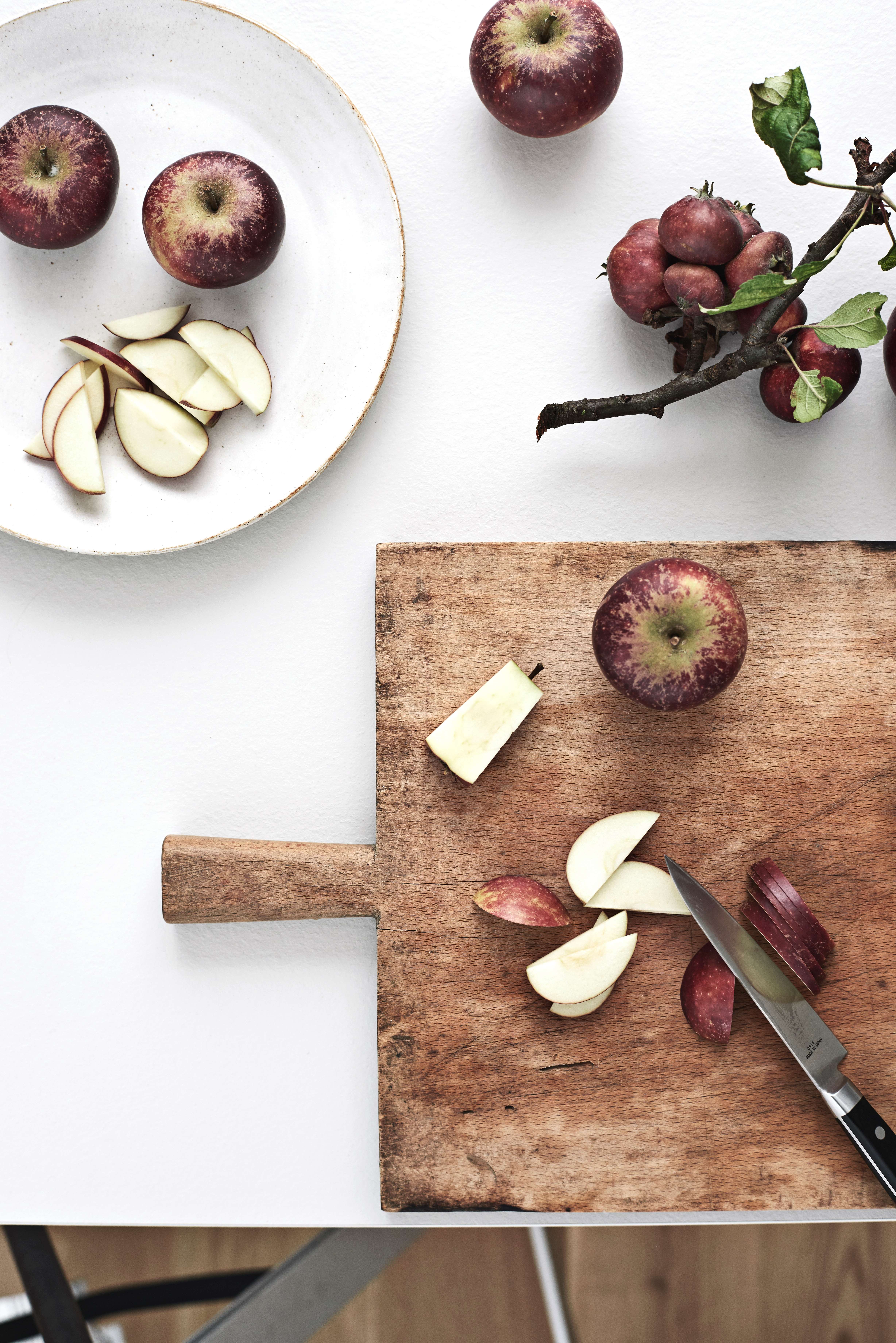 White worktop and a chop board with apples