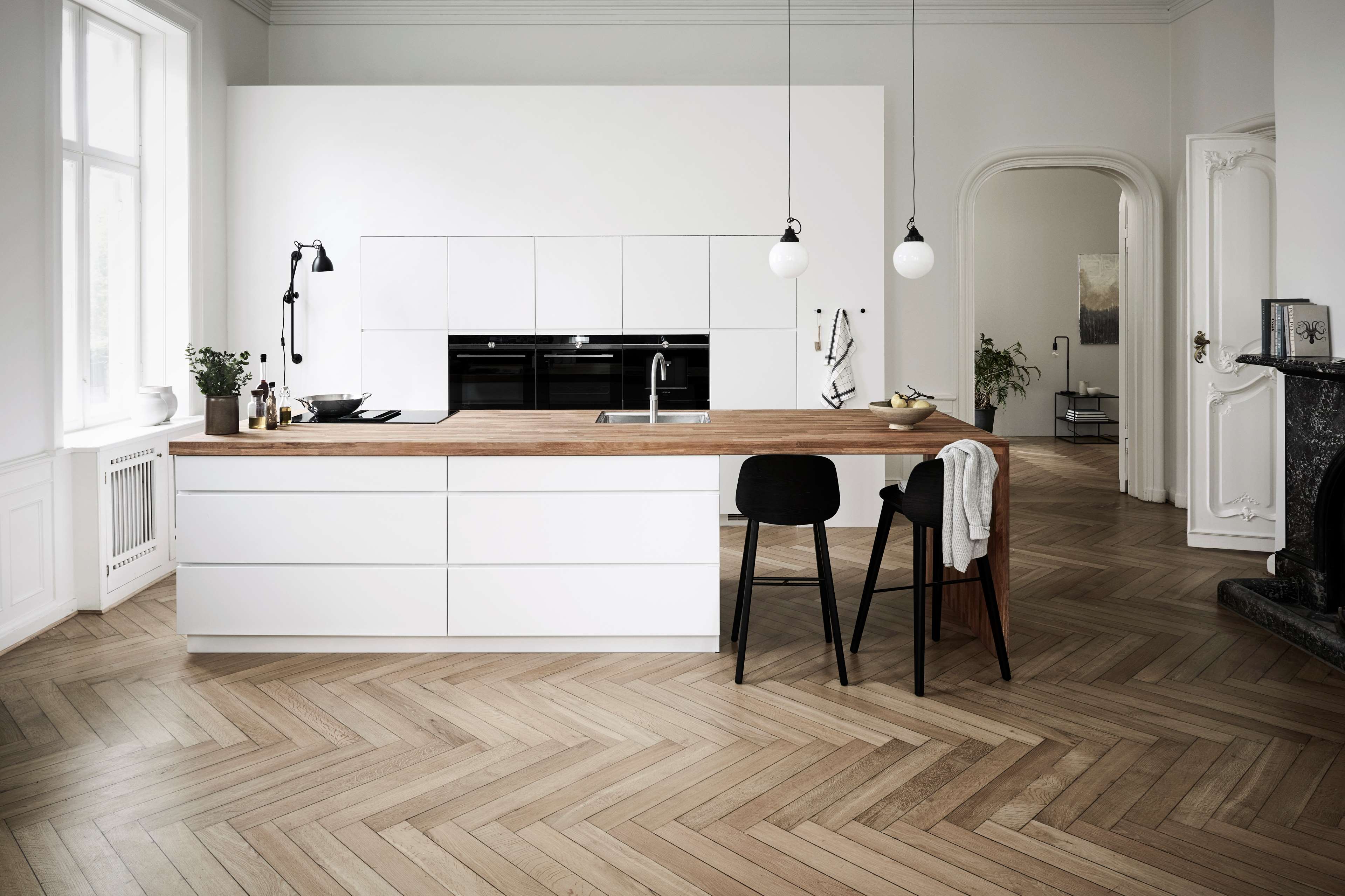 Witte keuken met een keukeneiland en een massief houten werkblad